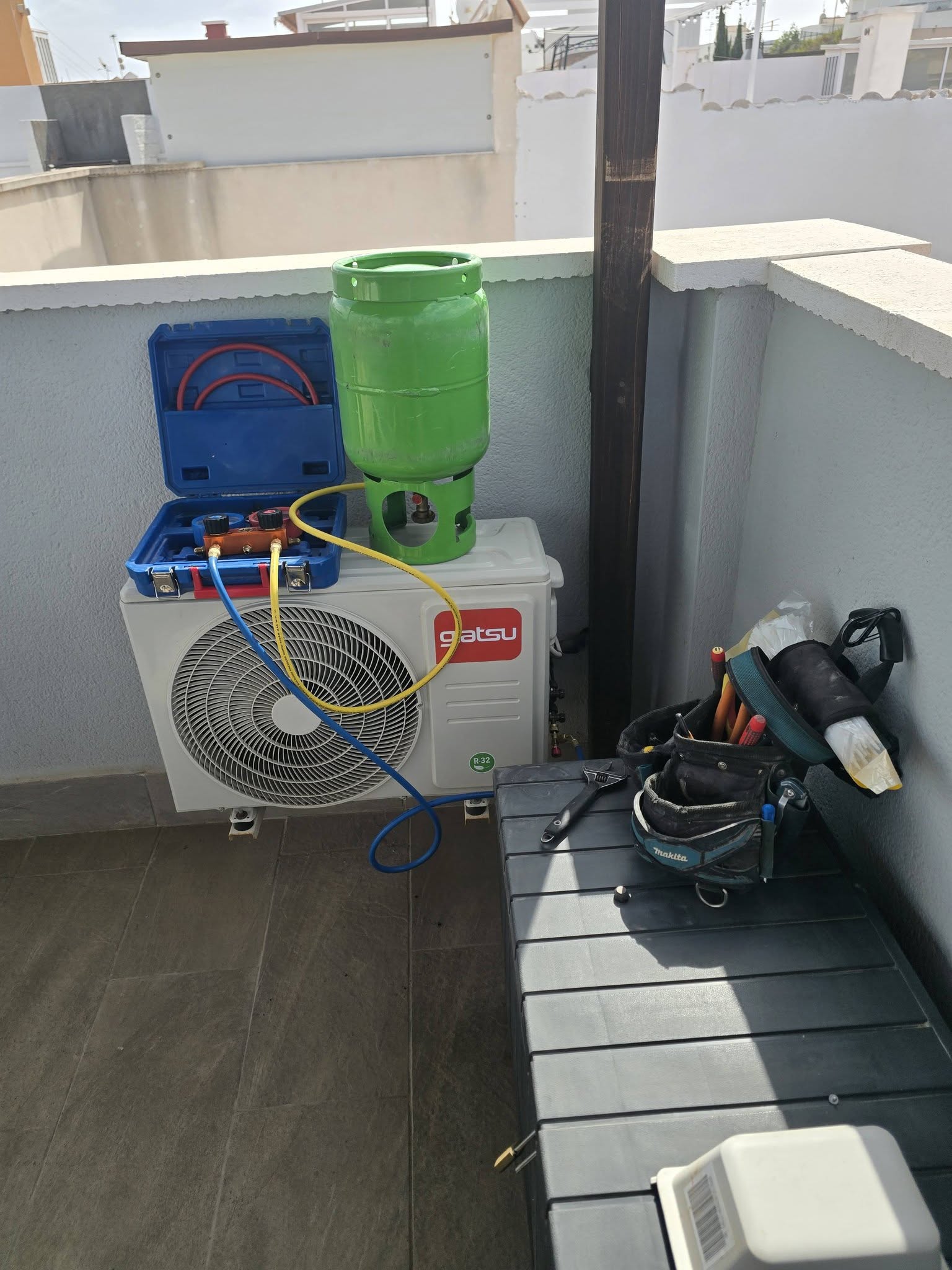AC installation and refrigerant pressure testing on a Giatsu outdoor unit