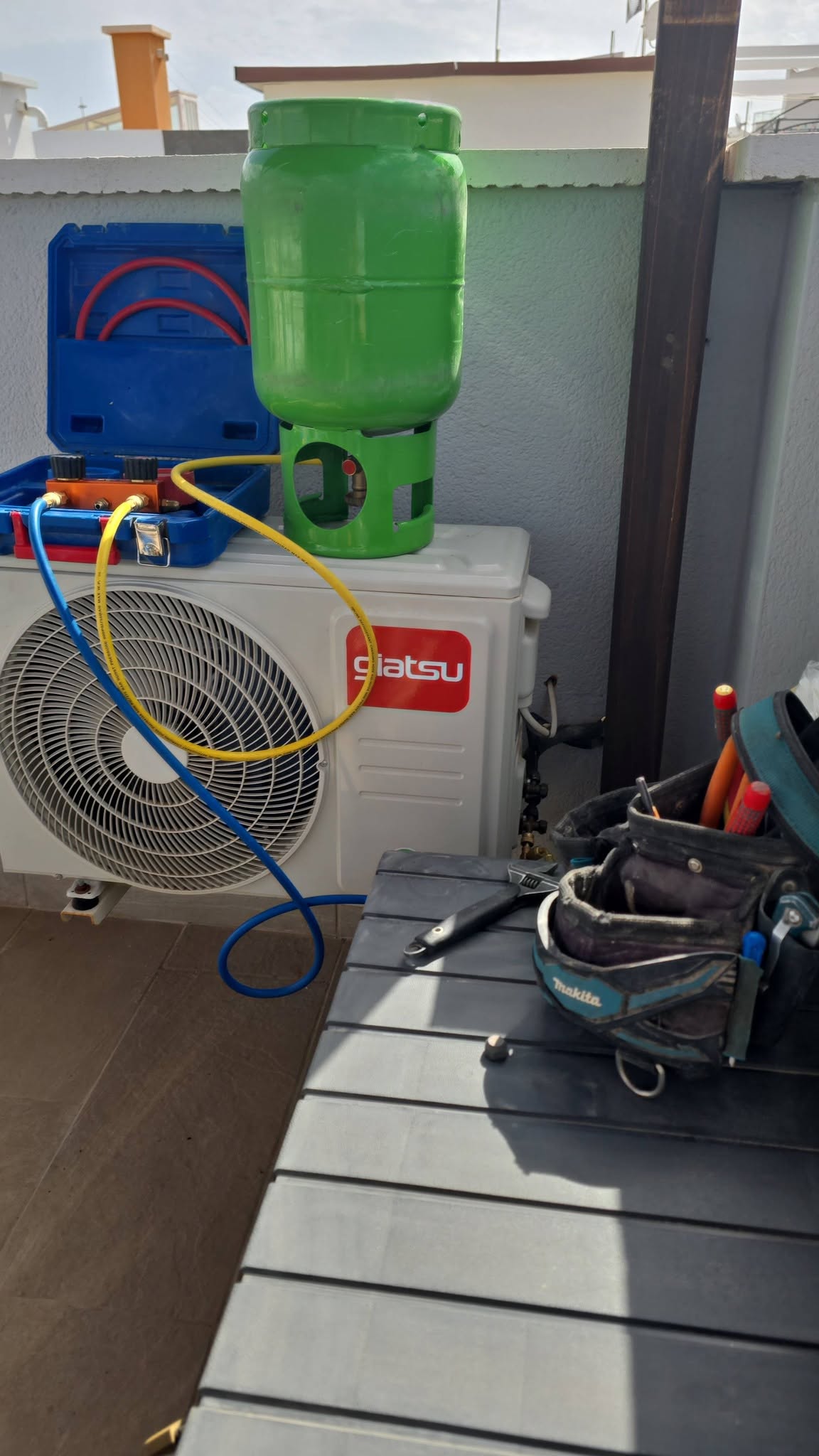AC installation and refrigerant pressure testing on a Giatsu outdoor unit